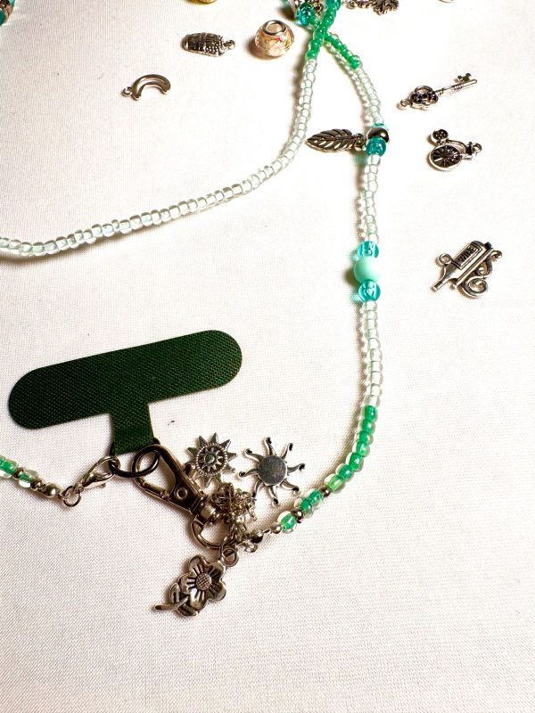 WhatsApp Image 2025-11-01 at 23.46.02 (2) CHAÎNE PERLÉE DANS UN TON VERT AVEC DES BRELOQUES ET MOUSQUETON ARGENTÉS.